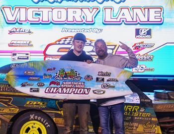 Mike Smith stands in victory lane after becoming the first-ever Clash On The Coast Karl Kustoms IMCA Northern SportMod champion alongside promoter Peyton Taylor. (Photo by AOM Creative)